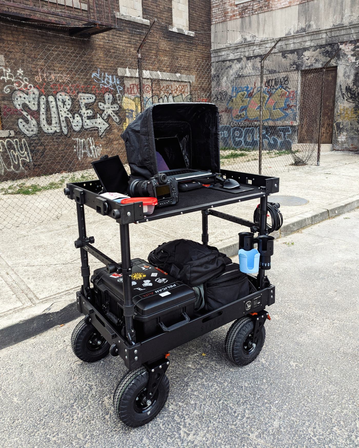 SYVOSH digital technician cart on location in a graffiti-covered alley