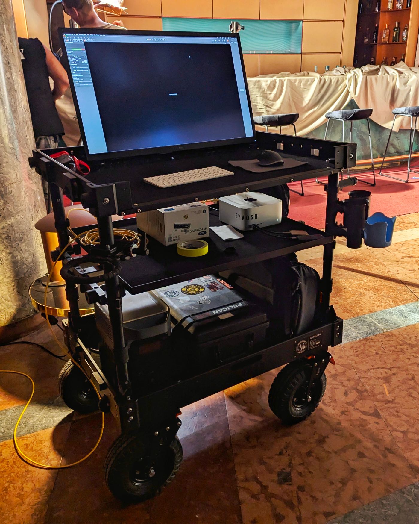 SYVOSH digital technician cart with dual monitors set up on a colorful lit film set